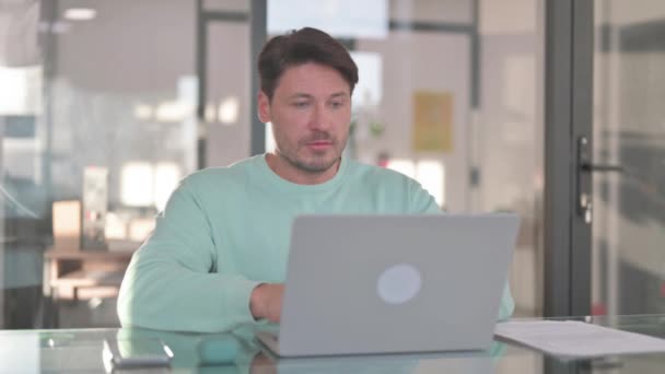 Man op zoek naar camera tijdens het werken op laptop - Video