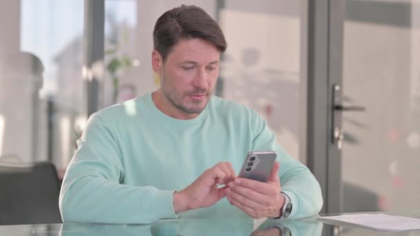 Middle Aged Man Celebrating Success on Phone - Footage, Video