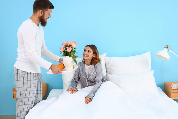 Young man bringing breakfast to his wife in bedroom - Photo, Image