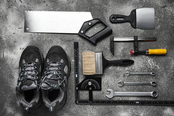 Set of construction tools and shoes on grey background - Photo, Image