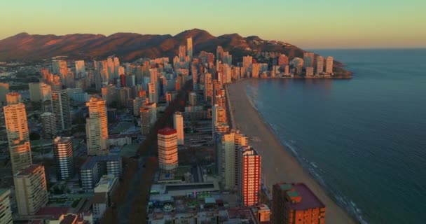 Benidorm, Spain. Skyline skyscrapers hotels and resorts, Benidorm seaside coastline. Aerial view of skyscrapers and beach of the touristic city of Benidorm in the Spain at sunset. - Footage, Video
