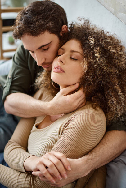 Embracing elkaars armen, krullend jonge vrouw en brunette man genieten van een rustige ochtend - Foto, afbeelding