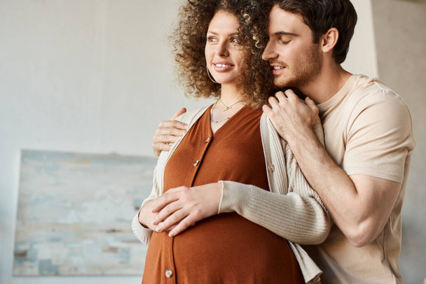 Loving young man and pregnant woman holding hands on belly, feeling inspired waiting for baby - Photo, Image
