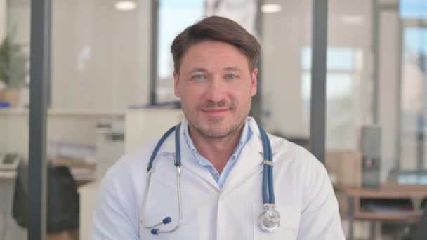 Portret uśmiechający się lekarza w klinice - Materiał filmowy, wideo