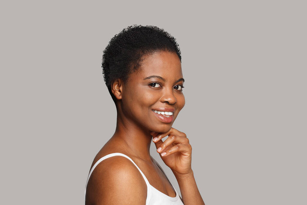 Piękna uśmiechnięta kobieta ze zdrową, czystą skórą na białym tle. Koncepcja leczenia twarzy, pielęgnacji skóry i kosmetologii - Zdjęcie, obraz