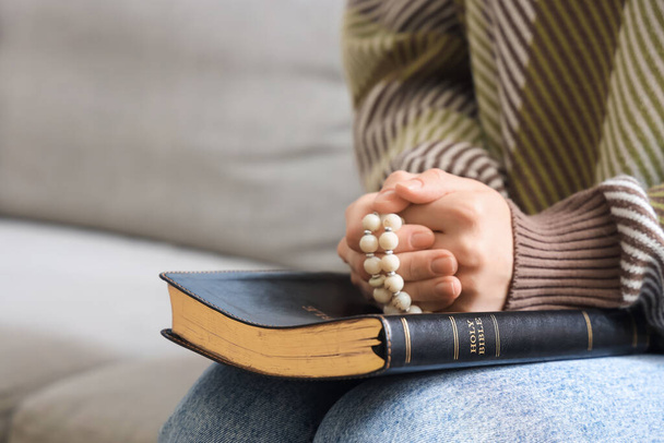 Młoda kobieta modli się na kanapie w domu - Zdjęcie, obraz