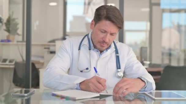 Médico escribiendo un tratamiento, informe médico - Metraje, vídeo
