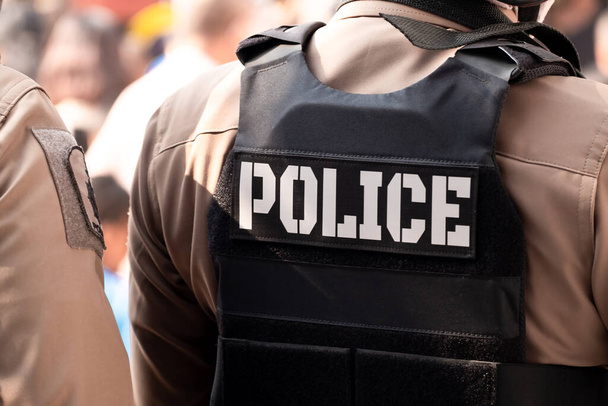 Vue arrière d'un policier habillé. Un gilet pare-balles sur son dos indique le mot police. Thaïlande uniforme de police, Protection et maintien de la paix et de l'ordre - Photo, image