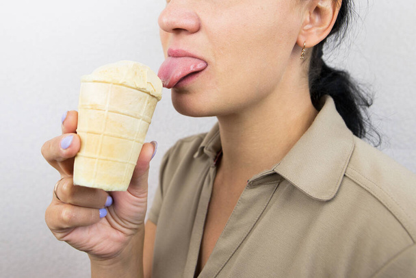 Dondurma yiyen bir kadının yakın çekimi. Kesilmiş fotoğraf. - Fotoğraf, Görsel