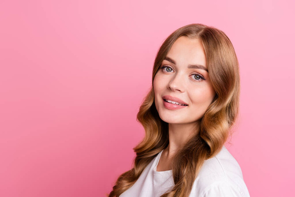 Portrait of adorable positive girl with wavy hairdo dressed white t-shirt near offer empty space isolated on pink color background. - Zdjęcie, obraz