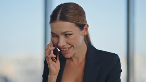 Портрет радісної леді говорить мобільний телефон на робочому місці. Щаслива бізнес-леді в костюмі дзвонить партнер, приємно розмовляючи в скляному офісі. Стильний менеджер з маркетингу, який спілкується клітинами, насолоджується мережею - Кадри, відео