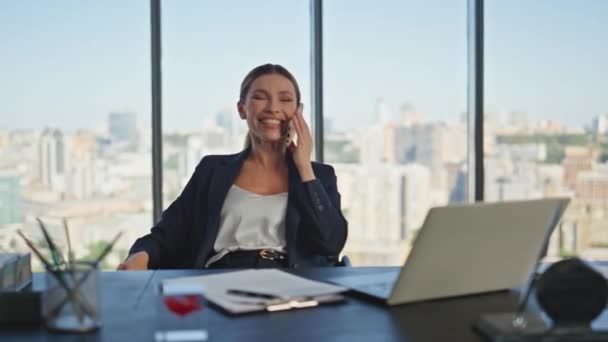 Χαρούμενη επιχειρηματίας καλεί κινητό τηλέφωνο στο παράθυρο πανοραμική. Χαμογελαστή κυρία αναπαύεται καρέκλα έχοντας φιλική συνομιλία στο γραφείο. Ξέγνοιαστες πωλήσεις πράκτορας γελάνε μιλάμε κελί. Γυναίκα στέλεχος στην εργασία - Πλάνα, βίντεο