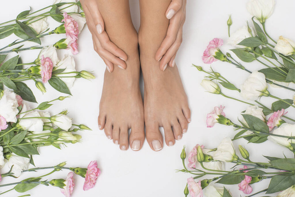 Bei piedi femminili con fiori sullo sfondo. - Foto, immagini