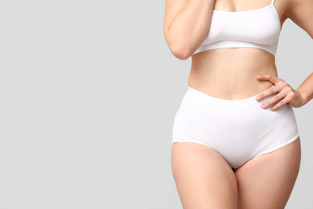 Тело позитивной женщины в нижнем белье на светлом фоне, крупным планом - Фото, изображение