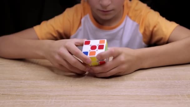 Een jongen die leert, hoe je de Rubiks kubus samenstelt. Rubiks Cube is een 3D combinatie puzzel Hoge kwaliteit 4k beeldmateriaal - Video