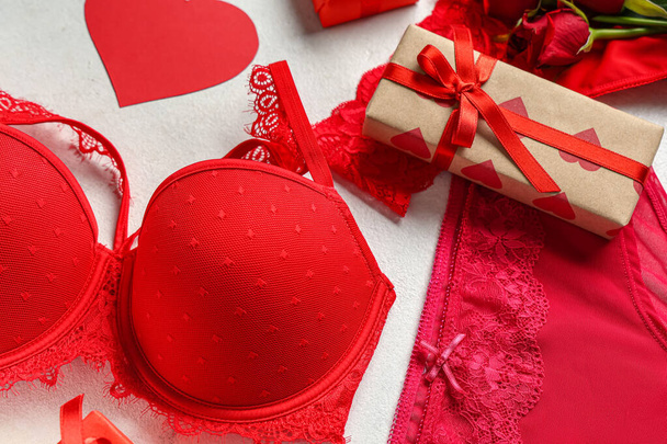 Sexy ropa interior roja con caja de regalo y rosas sobre fondo blanco. Celebración de San Valentín - Foto, Imagen