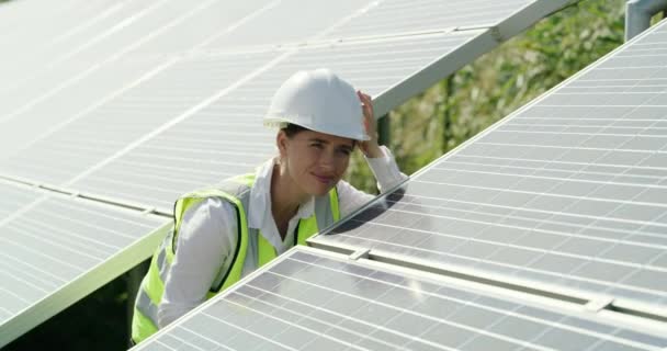 Napelem, mérnök és nő írótáblával a kültéri karbantartáshoz. Fotovoltaikus, ellenőrző lista és villanyszerelő az erőműben a fenntarthatóság érdekében. - Felvétel, videó