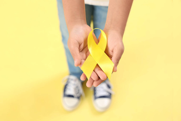 Mały Afroamerykanin z żółtą wstążką na tle koloru. Koncepcja świadomości na temat nowotworów u dzieci - Zdjęcie, obraz
