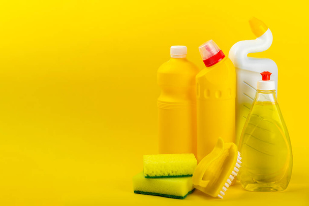 Siivouspalvelu käsite. Kodinpuhdistusaine keltaisella taustalla. Ämpäri kotitalouksien kemikaaleja. siivoustarvikkeet kodin tai toimiston tiloihin.Varhainen kevät säännöllinen siivous. Kopioi tila - Valokuva, kuva