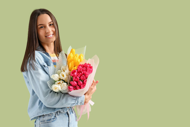 Jeune femme avec des bouquets de tulipes sur fond vert. Journée internationale de la femme - Photo, image