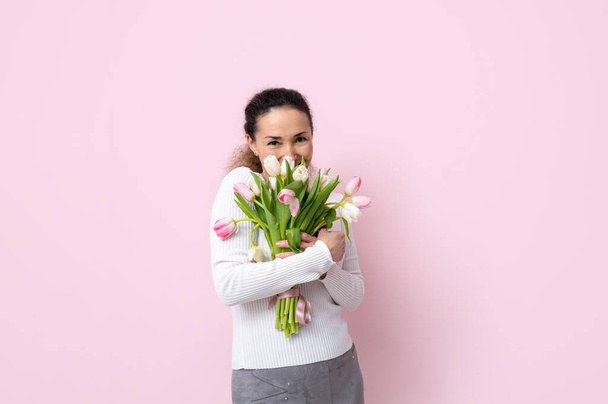 Mature woman with bouquet of beautiful tulips on pink background. International Women's Day - Zdjęcie, obraz