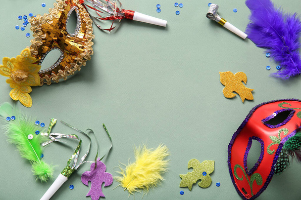 Рамка из карнавальных масок с рогами и декором для празднования Марди Гра на зеленом фоне - Фото, изображение