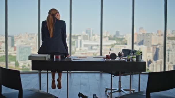 Ofisteki kadın iş yerinde çıplak ayakla oturuyor. Panoramik pencerede güzel şehir manzarası üzerine kafa yoran düşünceli sakin bir yönetici. Yorgun şirket yöneticisi huzurlu anın tadını çıkarıyor.. - Video, Çekim