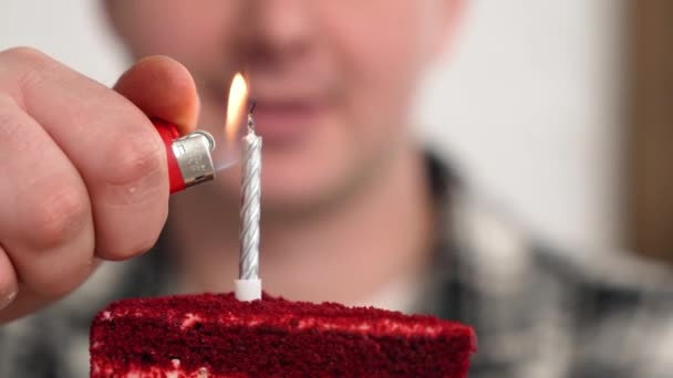 Обрізаний вигляд 30-х чоловік тримає торт на день народження з палаючими свічками, що дме вечірка свистить дивовижний чоловік зі святковою подією - Кадри, відео