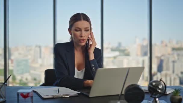 Financial manager talking smartphone at desk. Young businesswoman working laptop calling partner in modern panoramic office. Corporate sales employee speaking consulting client on mobile phone call. - Footage, Video