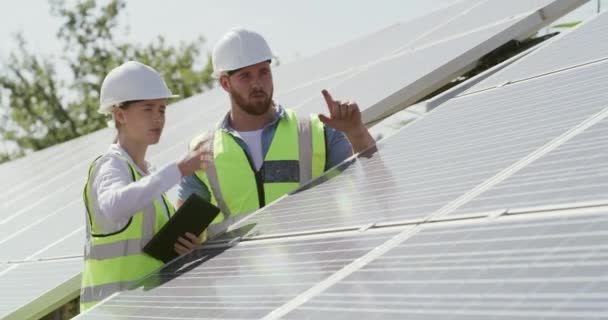 Engineer, team or people with tablet for solar panel maintenance, inspection or plan together. Photovoltaic power, technology or electrician in discussion for clean, green or renewable energy outdoor. - Footage, Video