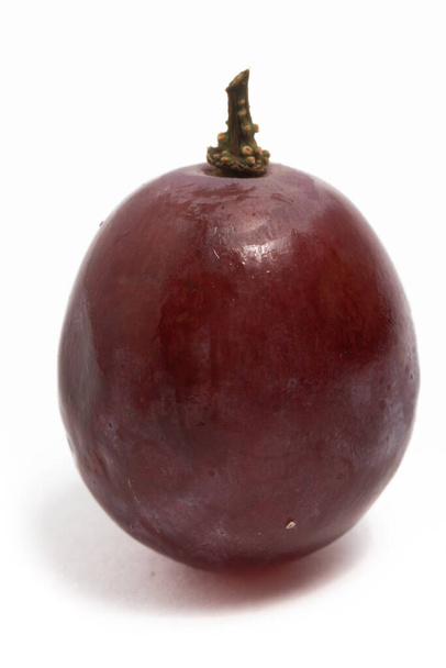 Primer plano de uvas rojas orgánicas frescas deliciosa fruta con una rama aislada en el camino de recorte de fondo blanco - Foto, imagen