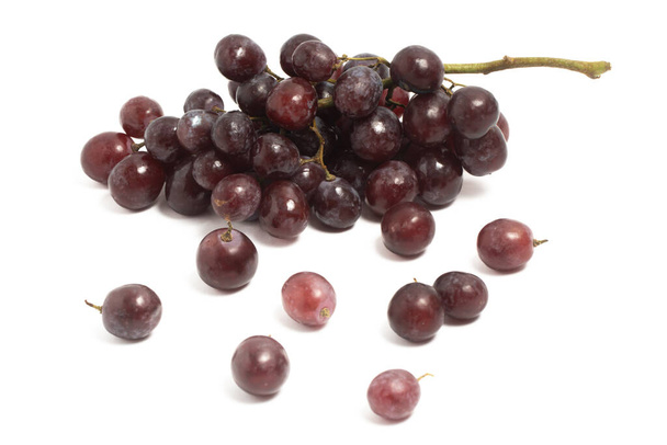Un racimo y separado de uvas rojas orgánicas frescas deliciosa fruta aislada en el camino de recorte de fondo blanco - Foto, imagen
