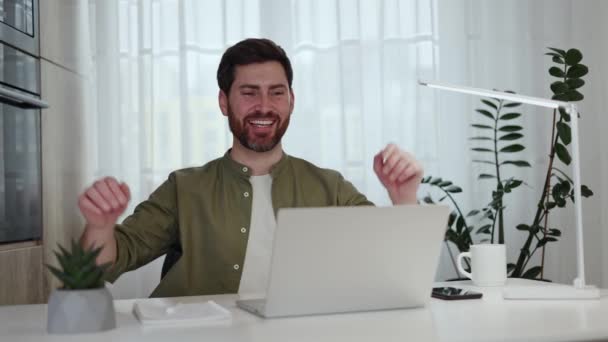 Portret zmęczonego białego mężczyzny siedzącego przy białym biurku, trzymającego ręce za głowę w biurze. Relaks stylowy mężczyzna uczucie szczęśliwy, ponieważ zakończyć tworzenie biznes planu na laptopie. - Materiał filmowy, wideo