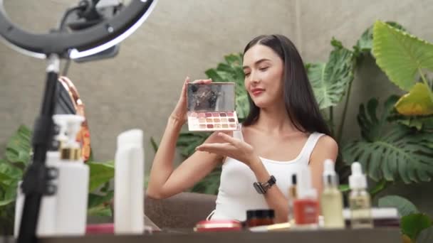 Beautiful content creator making natural beauty and cosmetic tutorial at green plant leave garden video. Beauty blogger showing how to apply beauty care to social medial audience. Blithe - Footage, Video