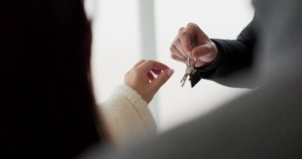 Het gelukkige paar krijgt de sleutels van hun nieuwe huis. Close-up van handen die de sleutel aan elkaar doorgeven. Concept van verkopen, kopen van een appartement. - Video