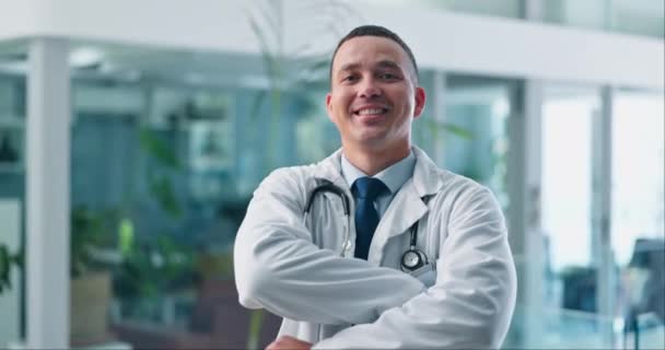 Doctor, man and face, arms crossed for healthcare and professional with expert, medicine and surgeon at hospital. Health, medical care and confidence in portrait, specialist and trust with smile. - Footage, Video