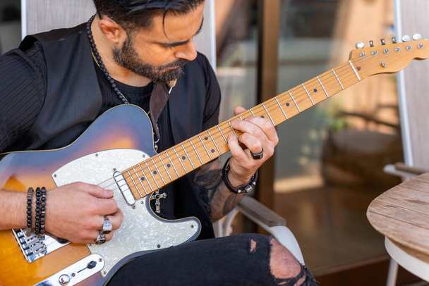 Hipster guitarist playing electric guitar outdoors - Photo, Image