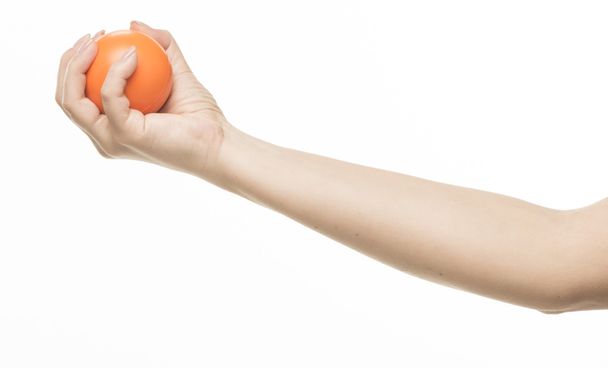 Mão feminina com bola de esponja laranja
 - Foto, Imagem
