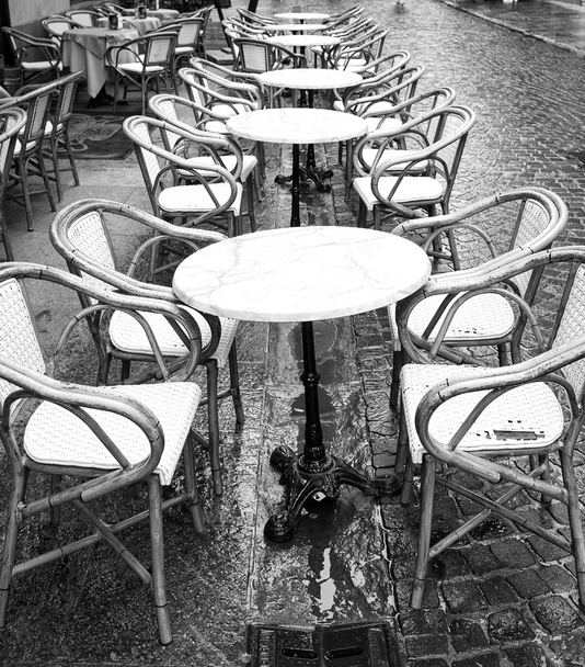 Mesa de bar bajo la lluvia. Imagen en blanco y negro
 - Foto, imagen