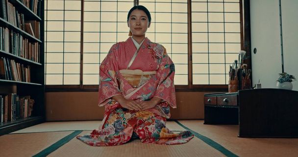 Japonka, tvář a kimono na obřad v pokoji Chashitsu a sedící na podlaze. Tradiční, módní nebo dívka s hrdostí, respektem a ctí pro kulturu, dědictví a čekání na matcha nebo čaj. - Fotografie, Obrázek