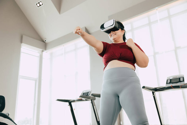 grube kobiety z VR zestaw słuchawkowy gry wizualnej rzeczywistości sportowej do ćwiczeń. ludzie wykorzystujący nowoczesne technologie do koncepcji opieki zdrowotnej. - Zdjęcie, obraz