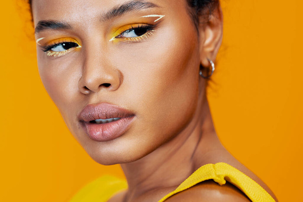 Όμορφη γυναίκα μαύρο make-up μοντέλο κίτρινο στυλ μόδας δημιουργική καλλυντική κοσμετολογία αντίγραφο ροζ πρόσωπο χώρο πολύχρωμο στούντιο ομορφιάς δέρμα πορτρέτο χαμόγελο Αφρικής - Φωτογραφία, εικόνα