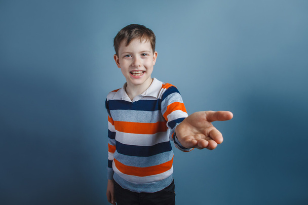 European-looking boy of ten years pulls his hand requests on a g - Photo, Image