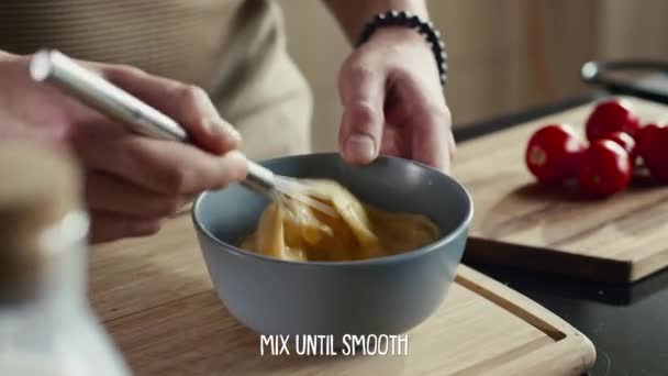 Közelkép a kezek élelmiszer blogger habverő tojás tálban főzés közben reggeli a konyhában, felirat leíró lépés közben megjelenő videó recept - Felvétel, videó