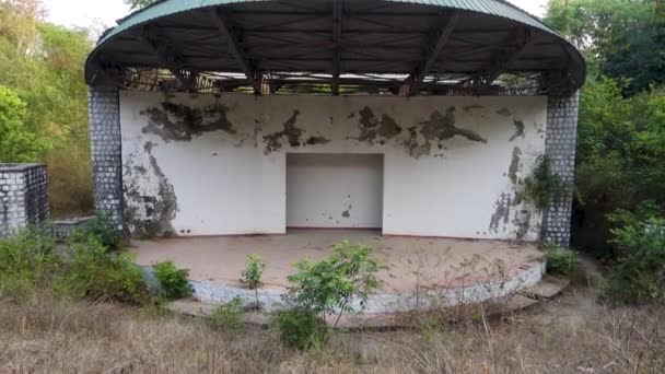 13 april 2022. Uttarakhand India. Lege overblijfselen van een slapend Auditorium gebouw vol wilde vegetatie rondom.. - Video