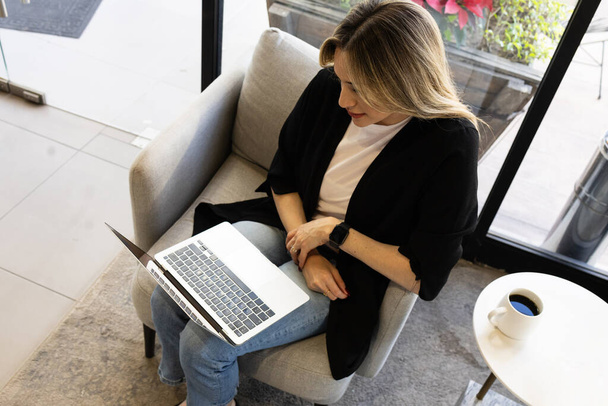 Wysoki kąt widzenia bizneswoman pracującej na laptopie w biurze - Zdjęcie, obraz