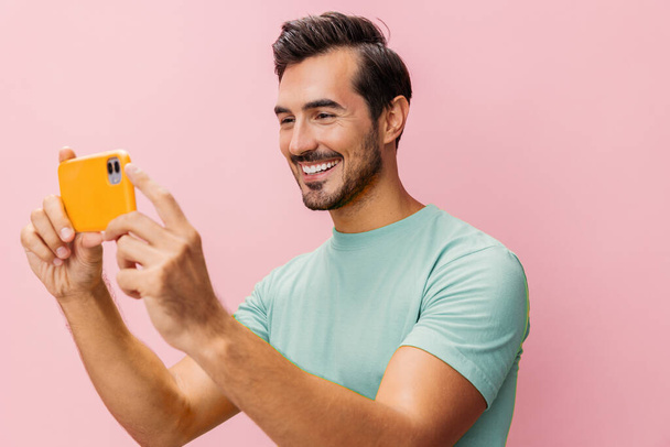 Mies tilalla elämäntapa elinkeinonharjoittaja älypuhelin tausta hymy menestys viesti bloggaaminen puhelin kyberavaruus liikemies onnellinen opiskelija viestintä vaaleanpunainen studio liiketoiminnan muotokuva mobiili - Valokuva, kuva