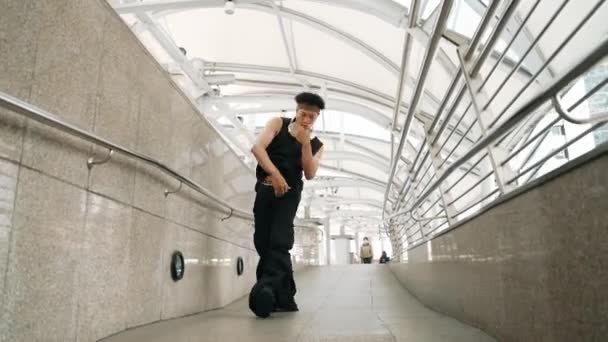 Calificado guapo hipster realizar baile callejero en pasillo estrecho. Bailarina de hip hop profesional mostrar b-boy paso en el pasillo de la ciudad urbana, mientras que el uso de tela con estilo. Deporte al aire libre 2024. Rígidamente.. - Metraje, vídeo