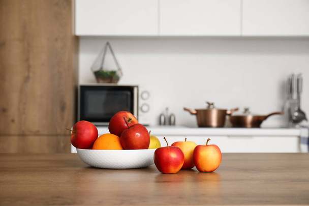 Tigela com frutas maduras na mesa na cozinha moderna - Foto, Imagem