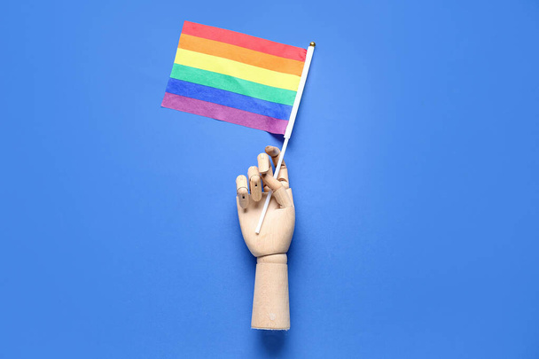 Дерев "яна рука з ЛГБТ - прапором на синьому тлі. - Фото, зображення
